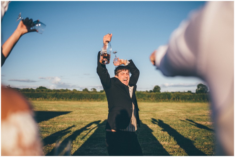Wedding guest holds glass on top of his head