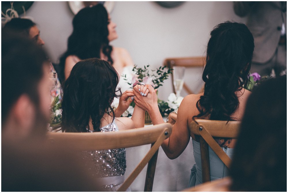 Bridesmaid and flower girl hold hands during the speeches at Rosehill House Hotel