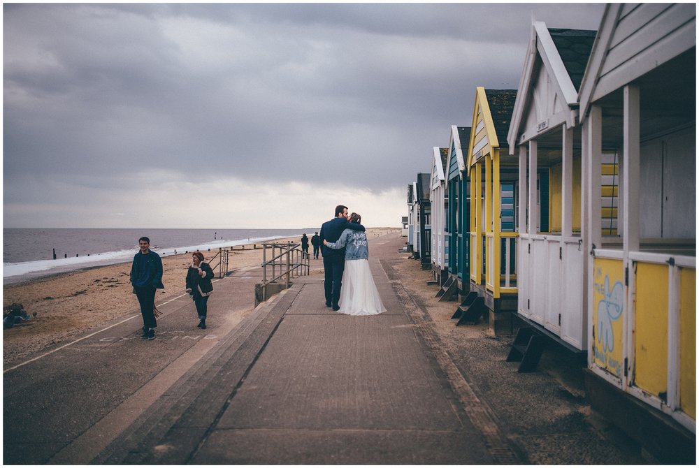 Bride and groom walk the pier at Southwold