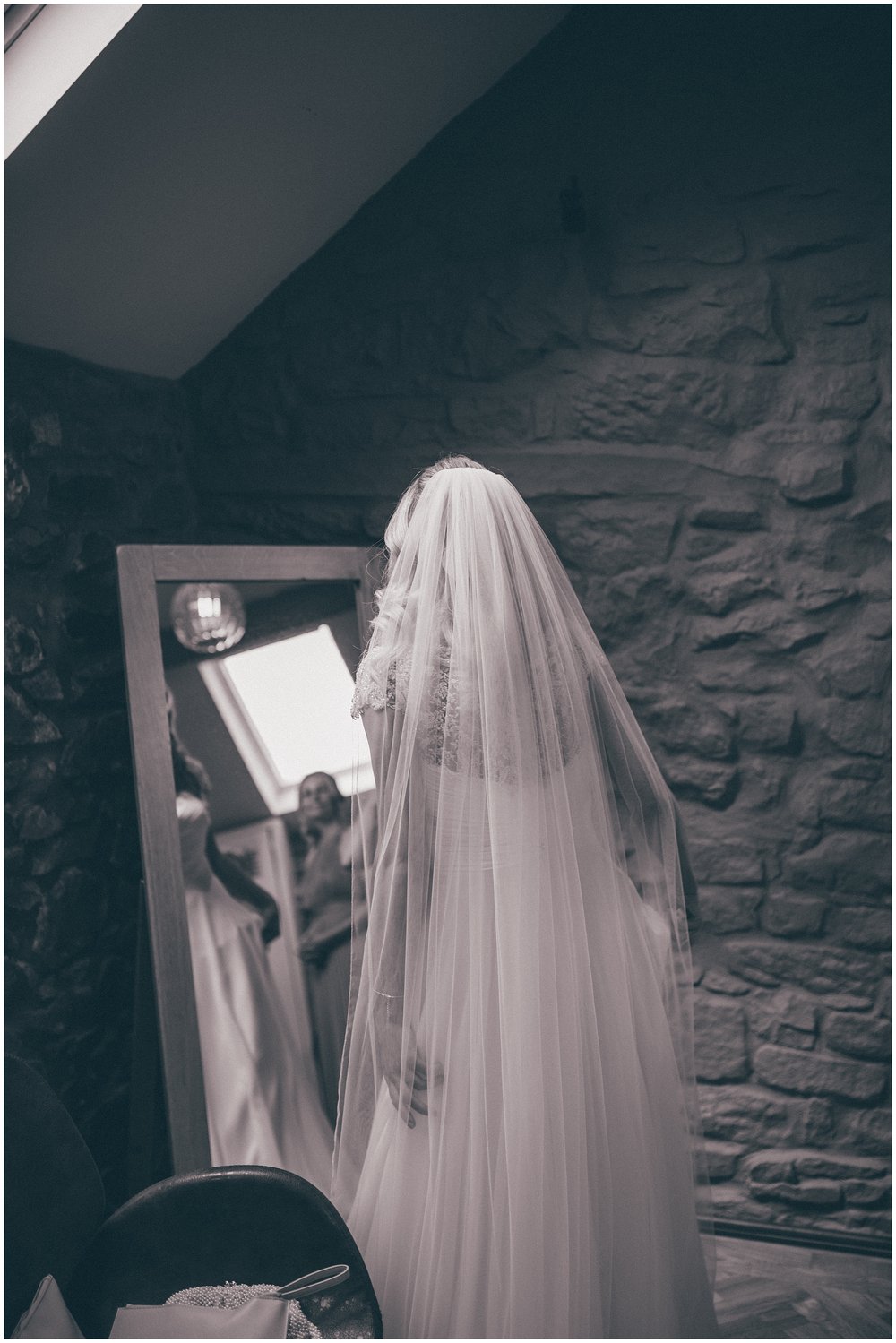 Bride looks at herself in the mirror before her wedding at Tower Hill Barns