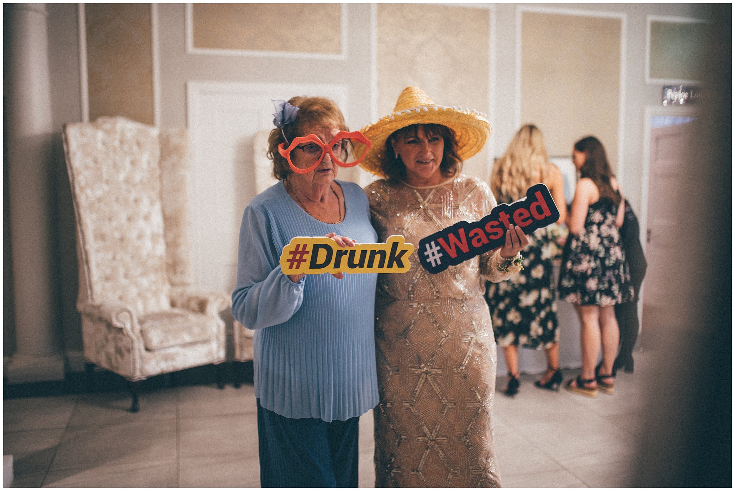 Guests take photos in front of the photo booth at the Old Palace wedding venue in Chester