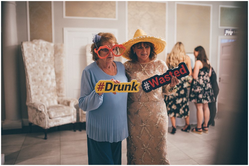 Guests take photos in front of the photo booth at the Old Palace wedding venue in Chester