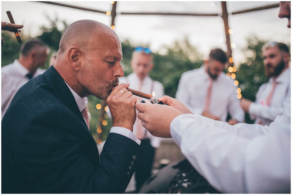 Guest lights cigar for the father of the bride at Skipbridge Country weddings