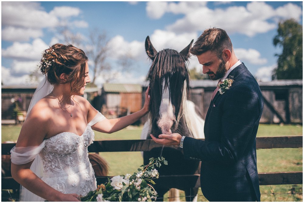 Bride and groom feed a horse at their Skipbridge Country wedding