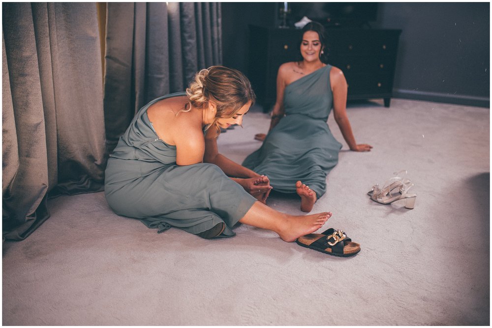 Bridesmaids massage eachothers feet at Oakwood at Ryther wedding