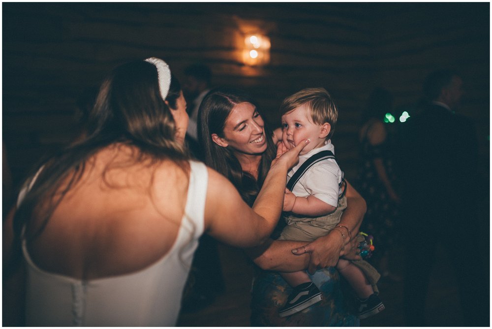 Bride squishes little boys cheeks at the Oakwood at Ryther wedding venue