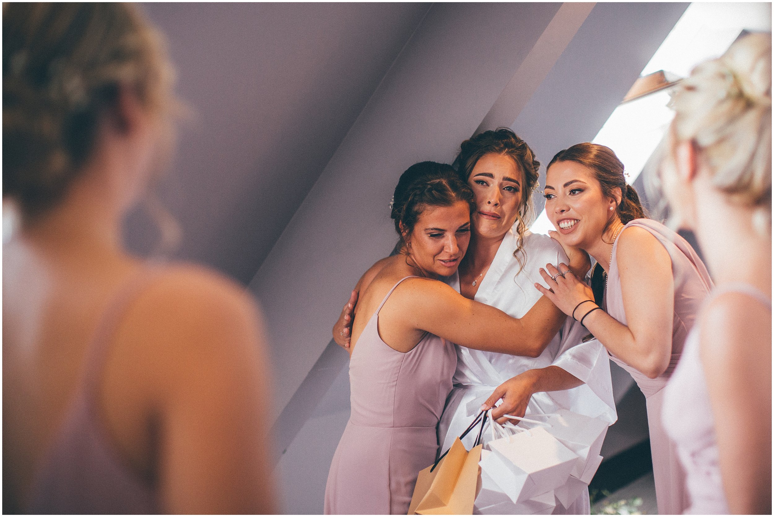 Bridesmaids cuddle the bride at Aldwark Manor in York