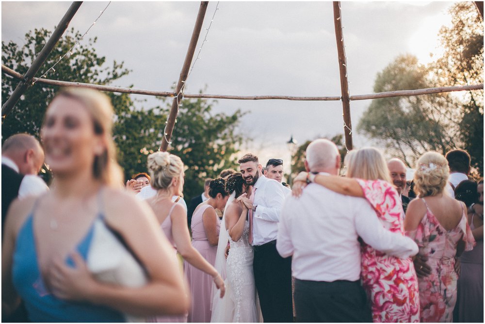 Wedding guests join the bride and groom and dance outside in the sun at Skipbridge Country wedding venue in Yorkshire