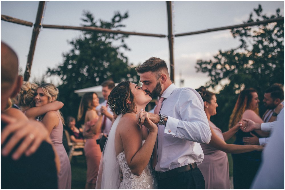 Wedding guests join the bride and groom and dance outside in the sun at Skipbridge Country wedding venue in Yorkshire