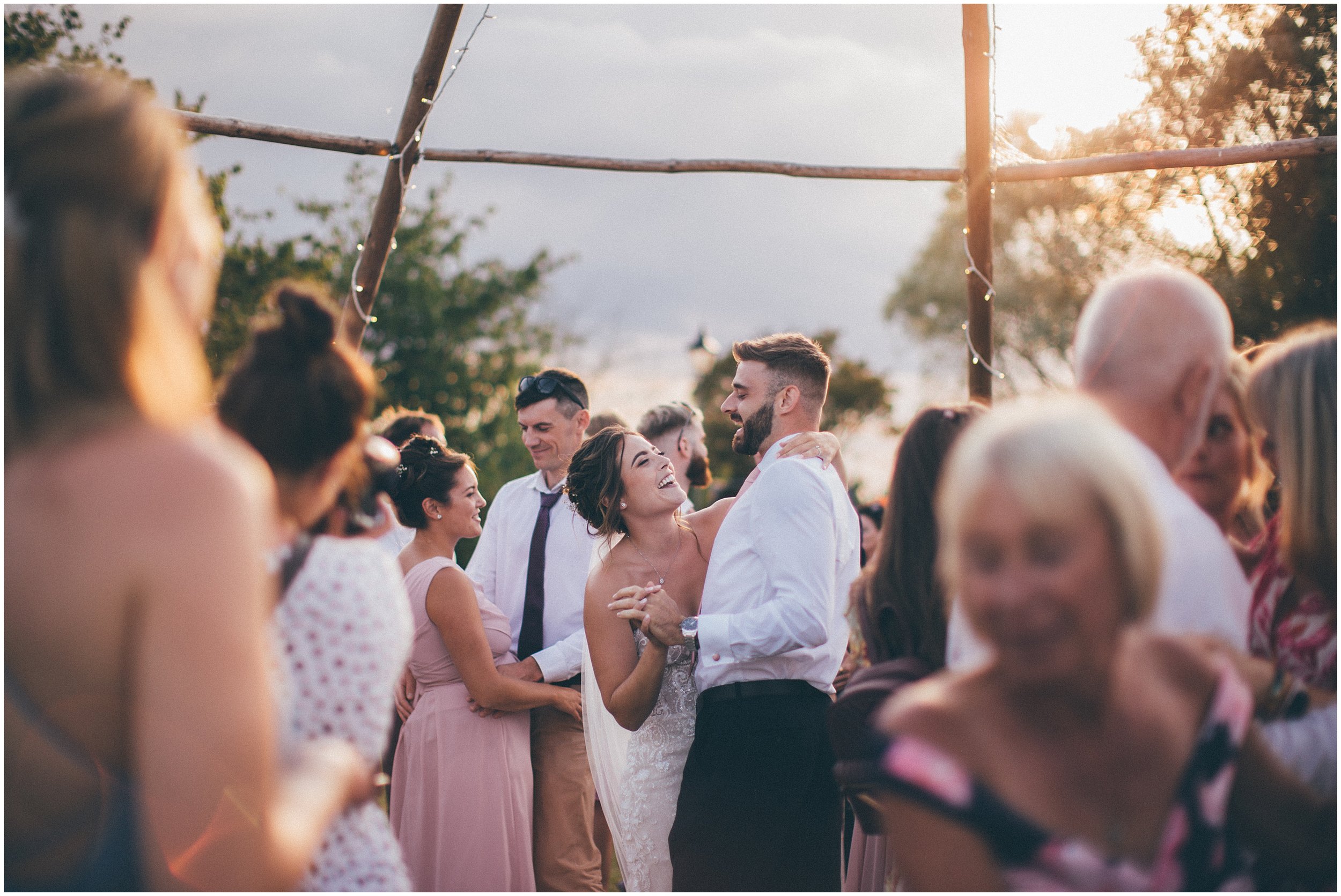 Wedding guests join the bride and groom and dance outside in the sun at Skipbridge Country wedding venue in Yorkshire