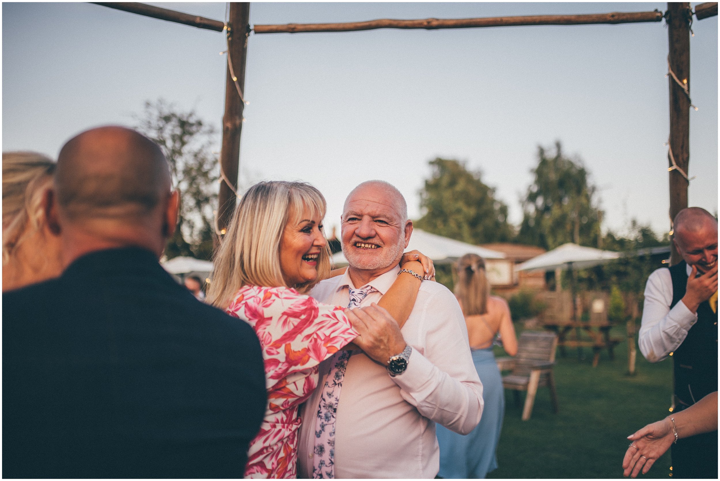 Wedding guests join the bride and groom and dance outside in the sun at Skipbridge Country wedding venue in Yorkshire