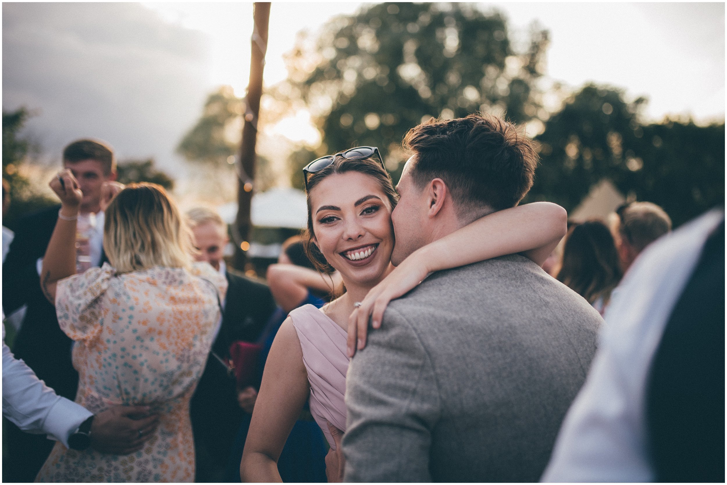 Wedding guests join the bride and groom and dance outside in the sun at Skipbridge Country wedding venue in Yorkshire