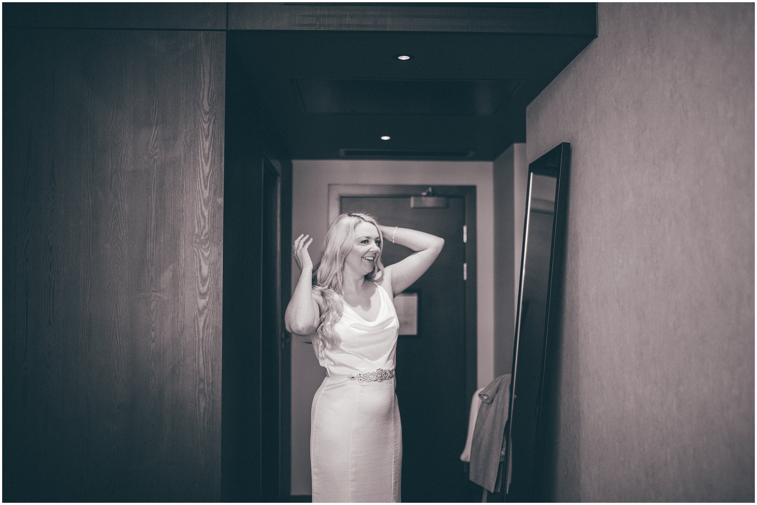 Bride puts on her dress at Radisson Red in Liverpool before her elopement wedding at St George's Hall in Liverpool