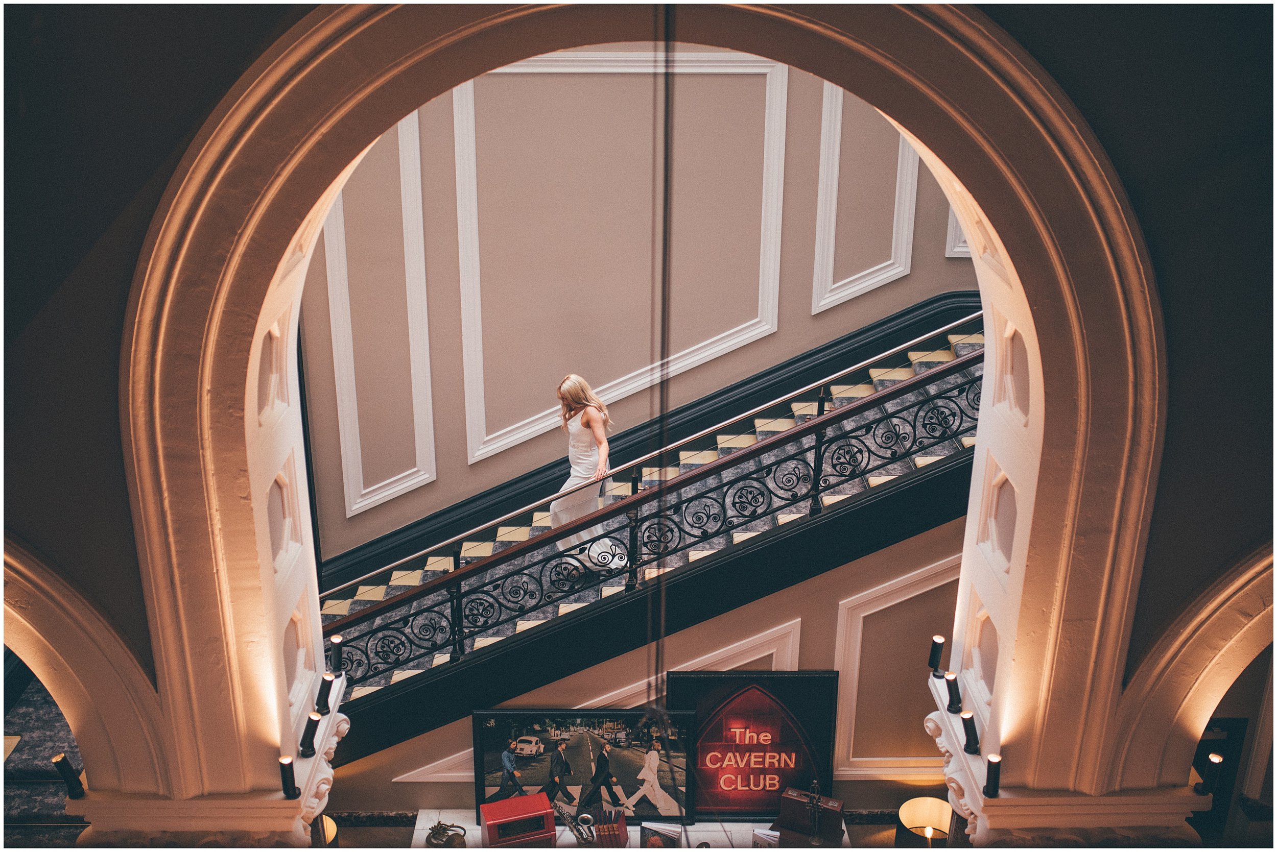Bride walks down the stairs at Radisson Red in Liverpool before her elopement at St George's Hall in Liverpool