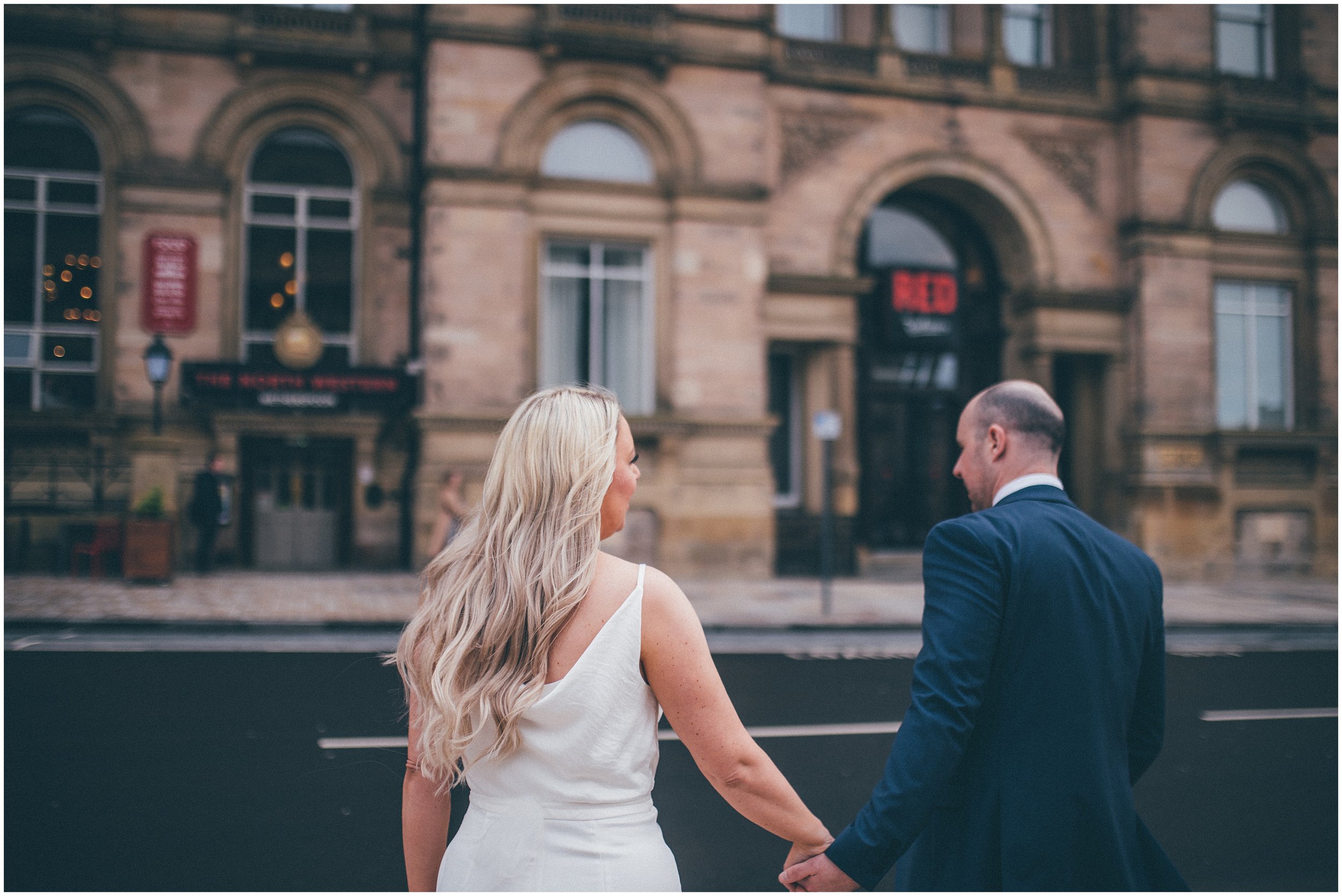 Bride and groom walk back to Radisson Red hotel after their elopement in Liverpool city centre at St George's Hall in Liverpool