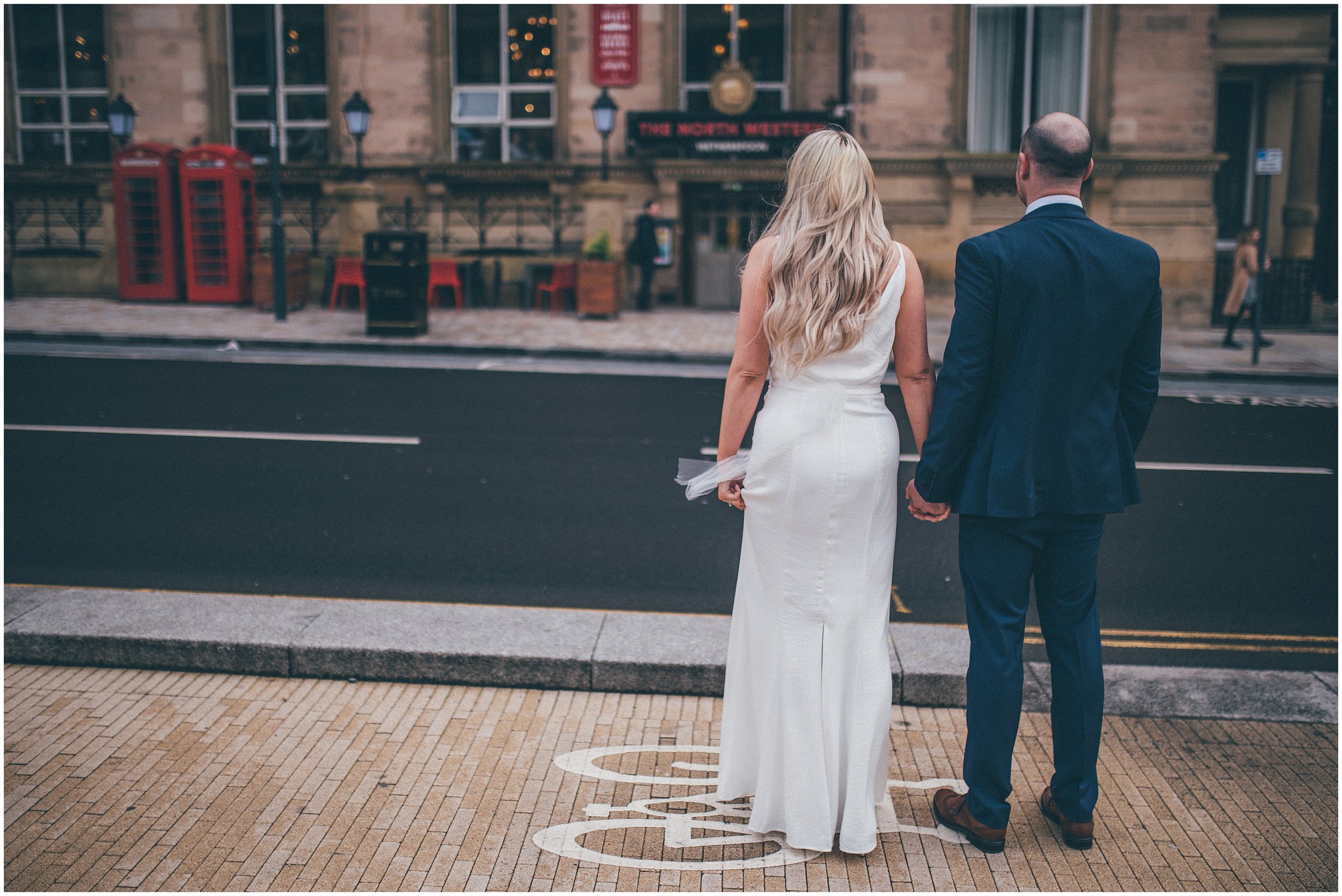 Bride and groom walk back to Radisson Red hotel after their elopement in Liverpool city centre at St George's Hall in Liverpool