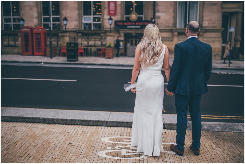 Bride and groom walk back to Radisson Red hotel after their elopement in Liverpool city centre at St George's Hall in Liverpool