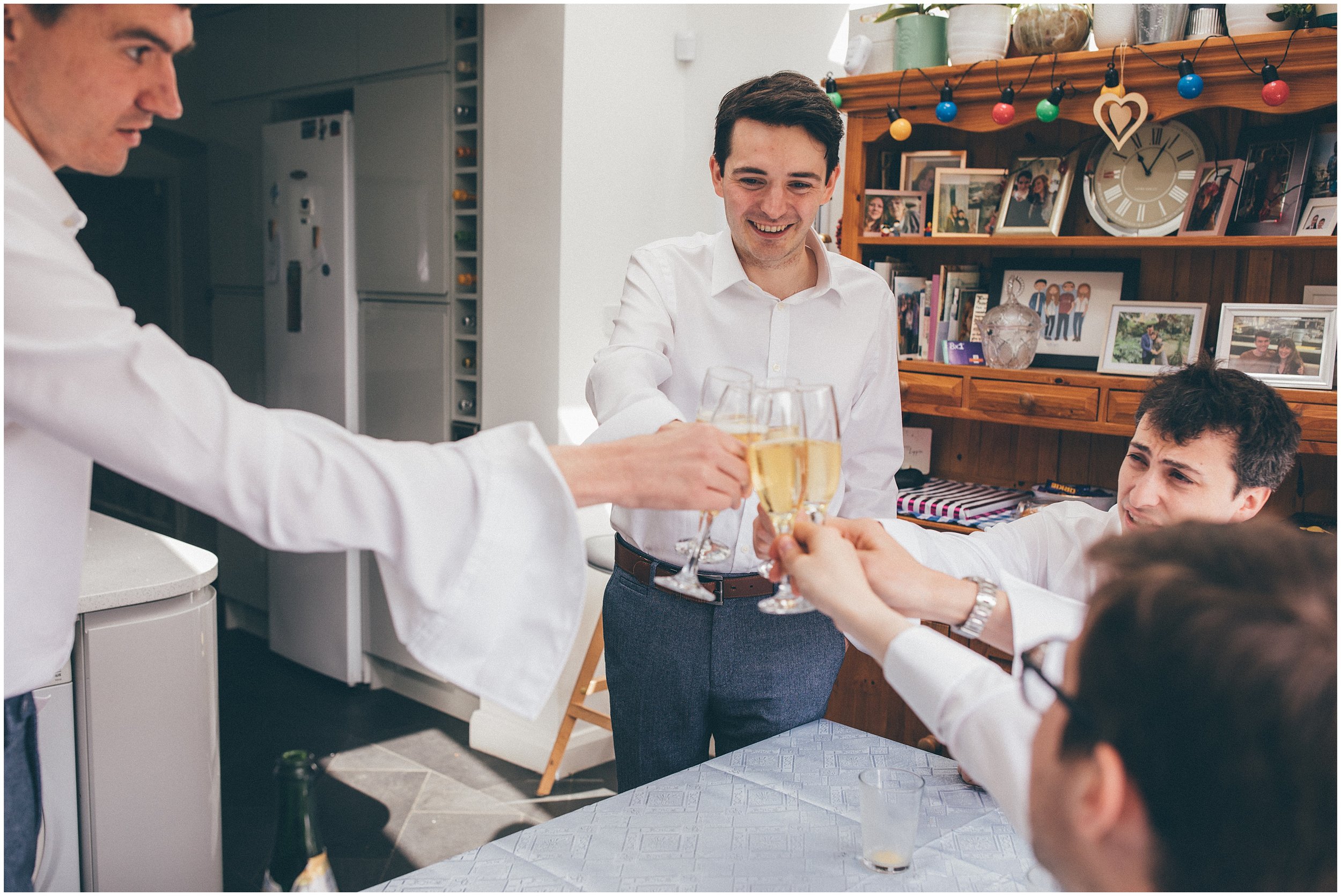 Groom and his groomsmen celebrating with champagne before the summer wedding at Sefton Palm House in Liverpool