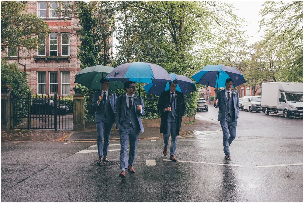 Groom and his groomsmen walking in the rain to Sefton Palm House in Liverpool