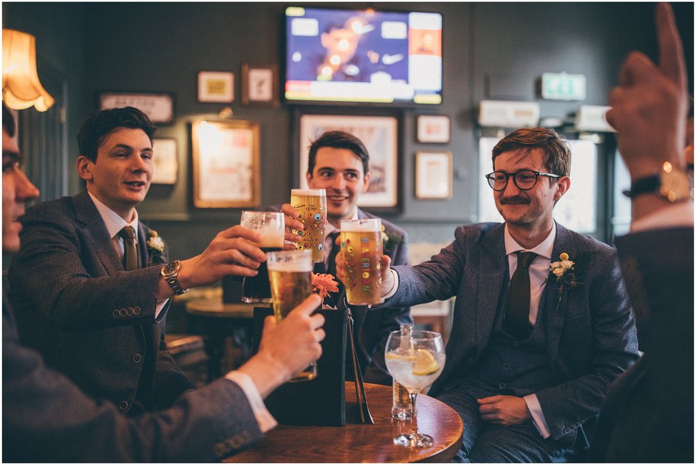 Groom and his groomsmen drink pints in the pub and cheers ahead of the wedding at Sefton Palm House in Sefton Park, Liverpool