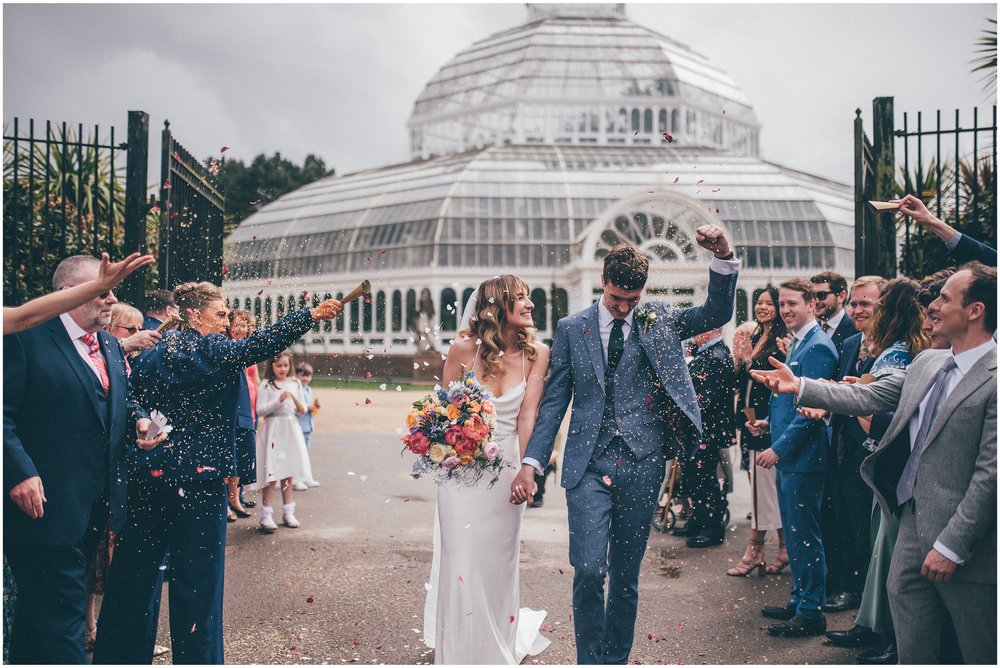 Bride and groom have confetti thrown all over them after their wedding ceremony at Sefton Palm House in Liverpool.