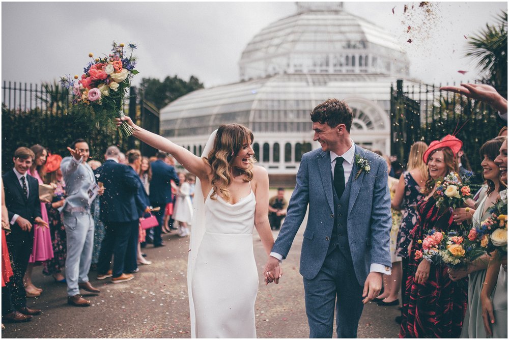 Bride and groom have confetti thrown all over them after their wedding ceremony at Sefton Palm House in Liverpool.