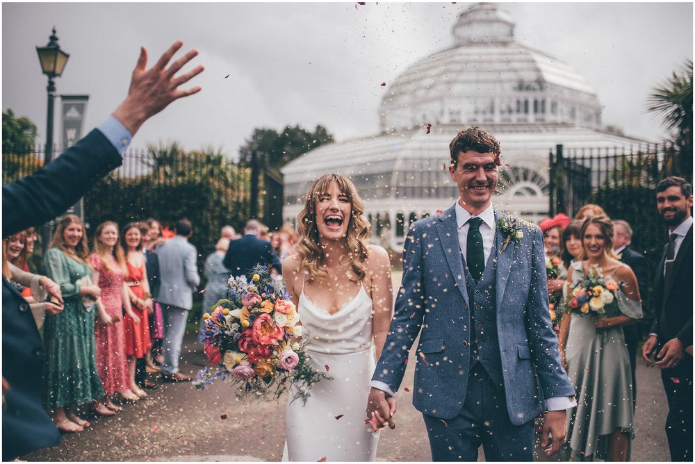 Bride and groom have confetti thrown all over them after their wedding ceremony at Sefton Palm House in Liverpool.