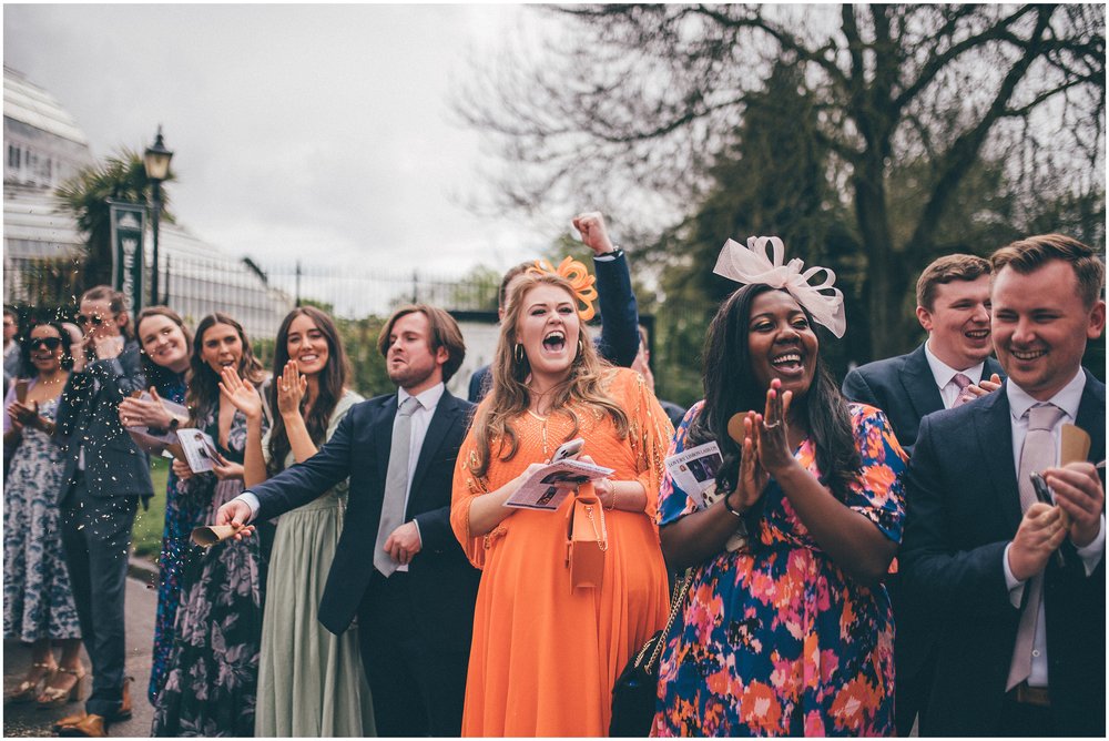 Bride and groom have confetti thrown all over them after their wedding ceremony at Sefton Palm House in Liverpool.