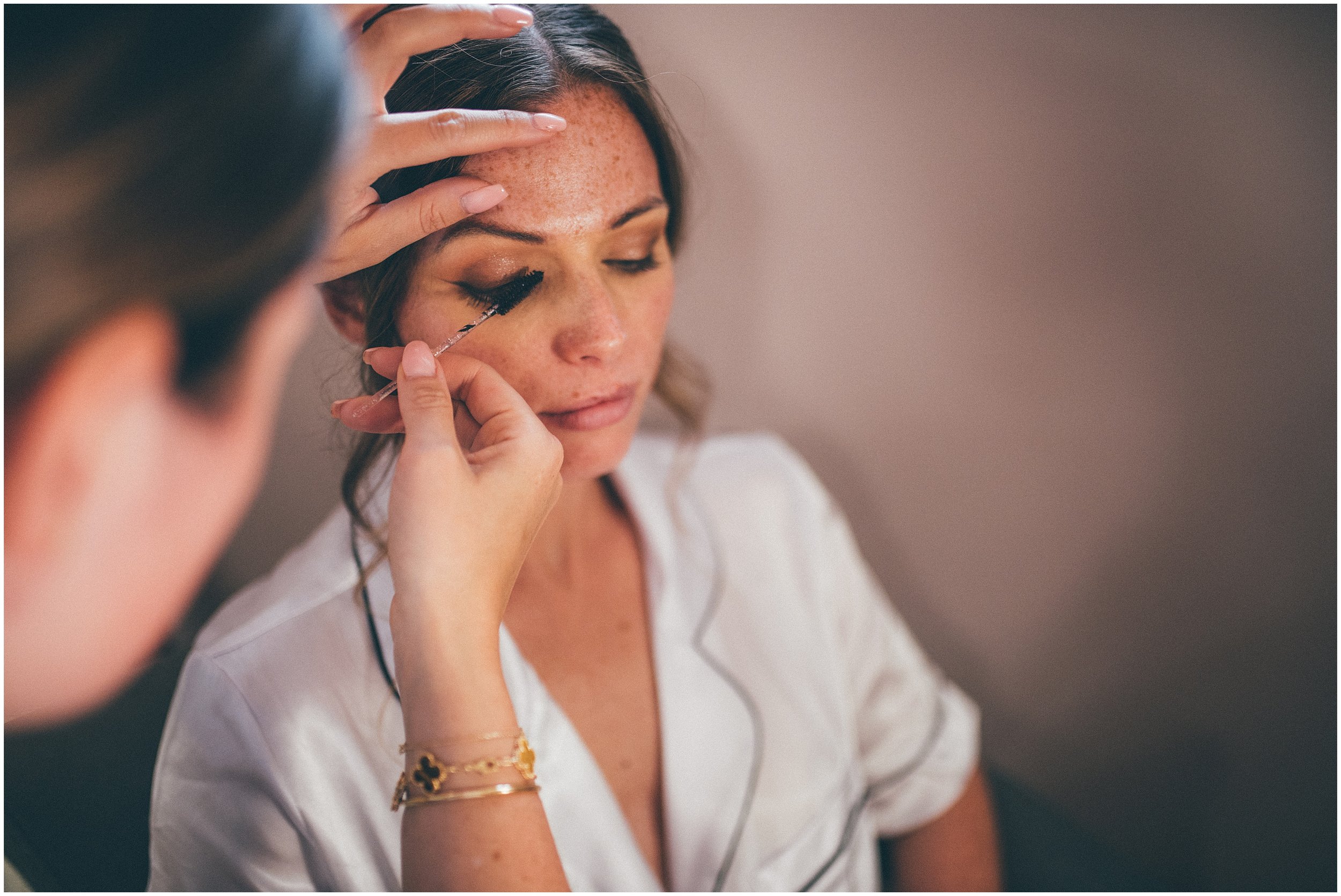 Bride gets her make-up done on her wedding morning at Abbeywood Estate in Delamere