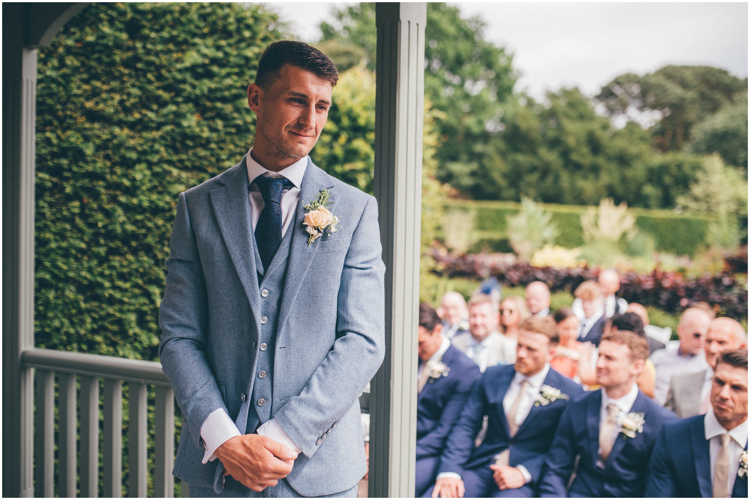 Groom waits for his bride at their outdoor wedding ceremony at Abbeywood Estate wedding venue in Delamere, Cheshire