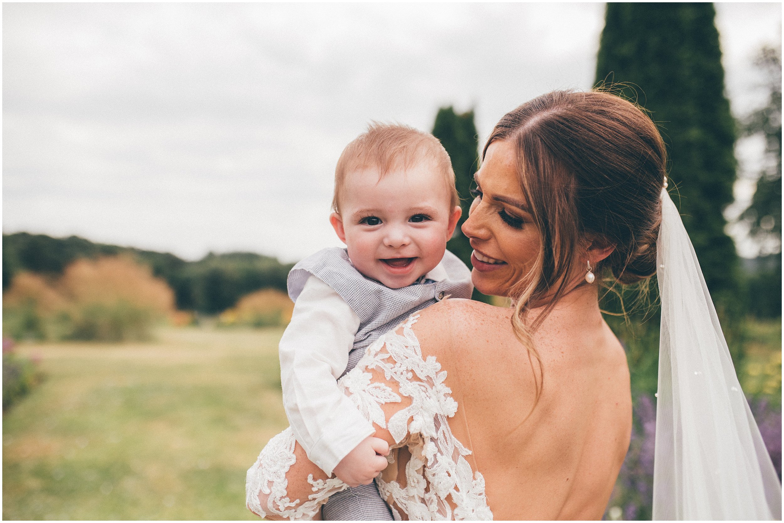 Beautiful bride and her son enjoy the pretty gardens at Abbeywood Estate in Delamere, Cheshire.