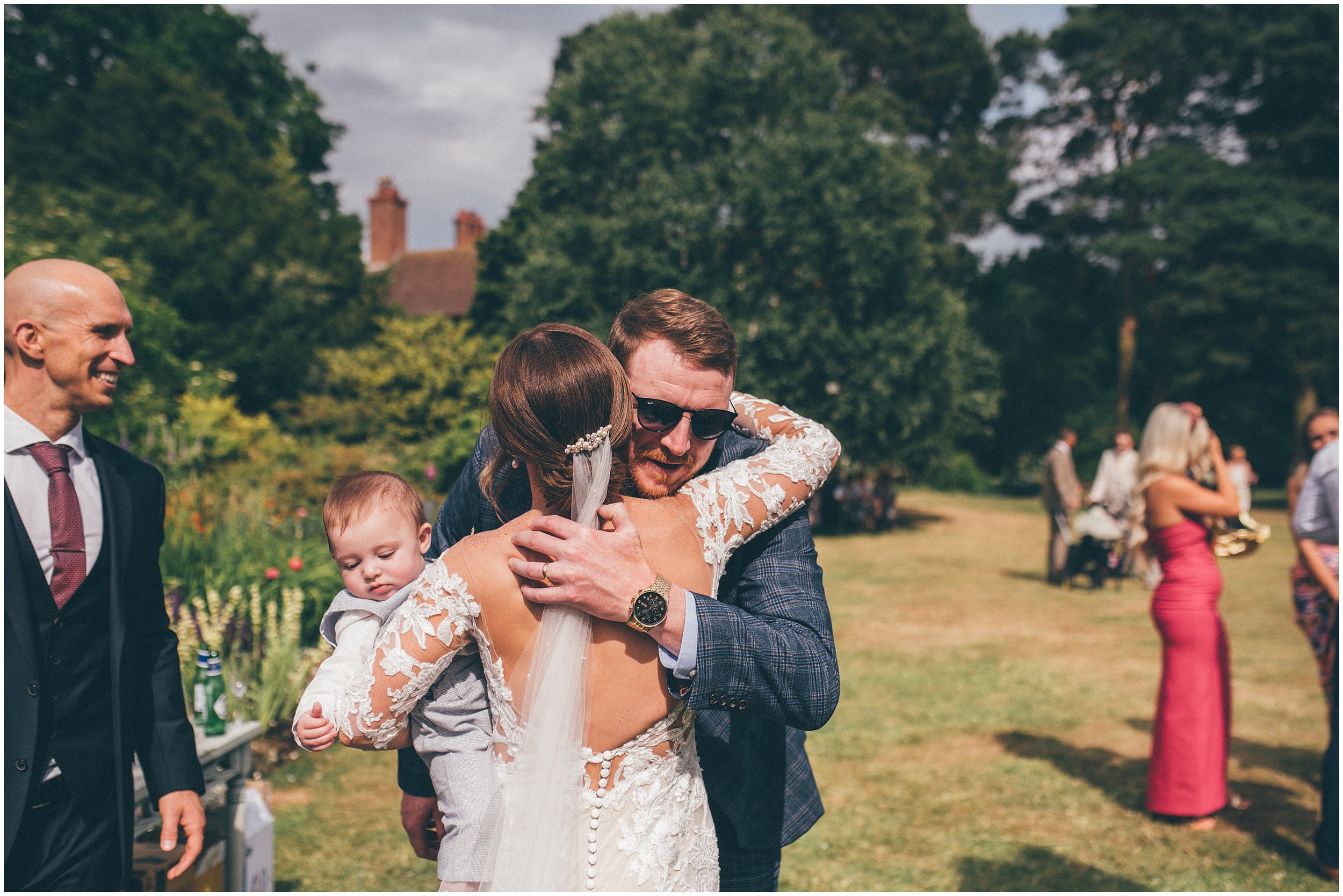 Wedding guests enjoy the beautiful gardens at Abbeywood Estate in Delamere, Cheshire for a summer wedding reception.
