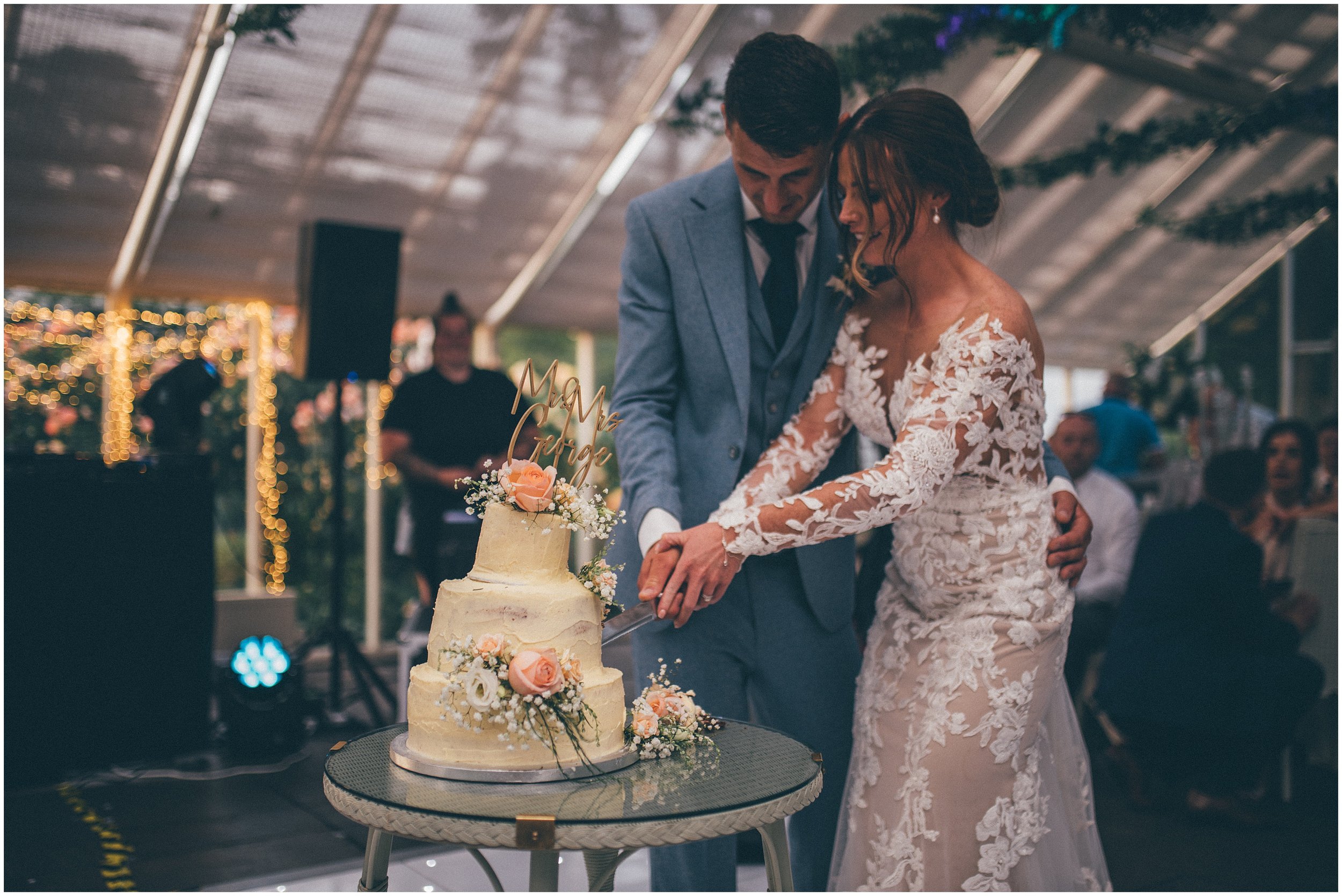 Bride and groom cut their wedding cake at Abbeywood Estate wedding venue in Delamere, Cheshire.