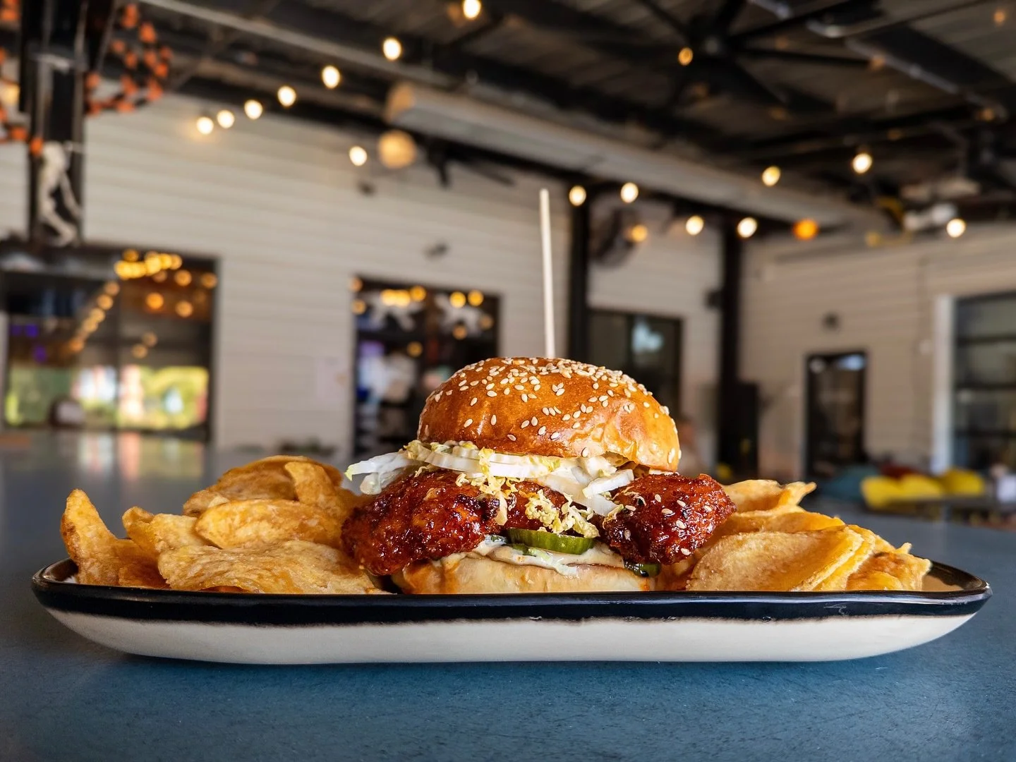 KOREAN SWEET AND SPICY CHICKEN SANDWICH 
panko breaded chicken breast topped with charred scallion aioli, shredded Napa cabbage, Ssamjang, and Korean quick pickles on a house bun. 
Pair with LEANING TOWER OF PILSNA, Italian Pilsner available on draft