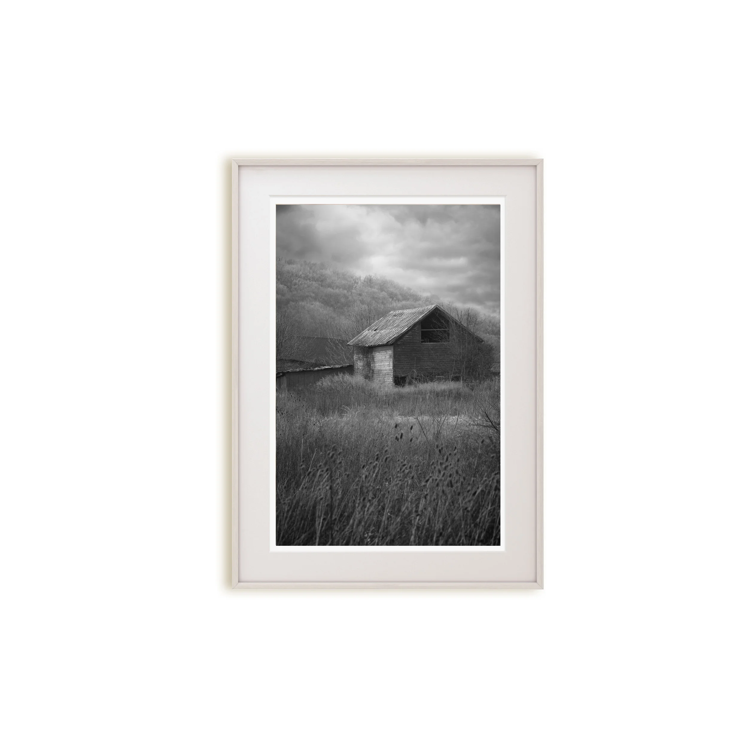 A moody black and white print of an abandoned building