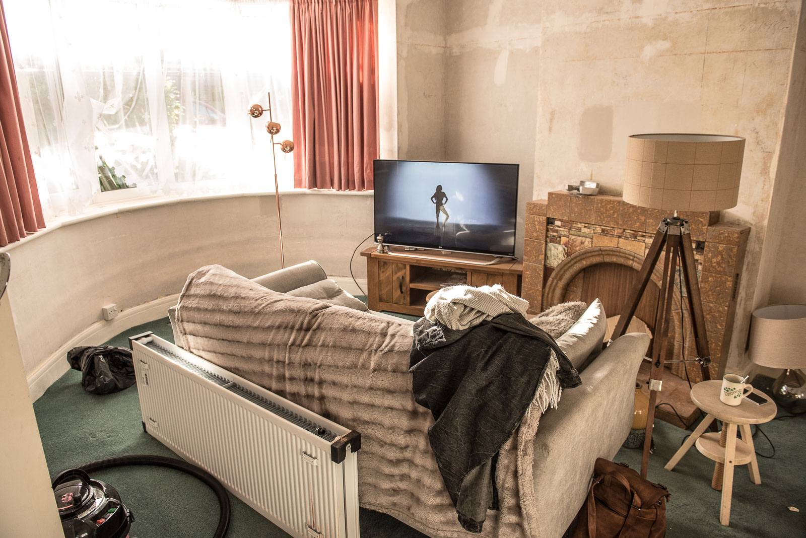 Living room furniture is all moved to the centre of the room for radiator installation/wall paper stripping 