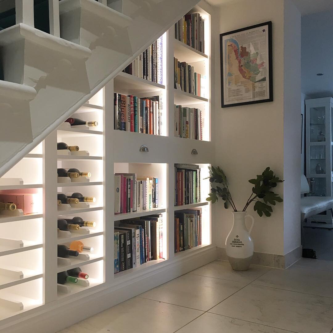 Built in book and wine storage area under stairs - IMAGE: @matthewmccrossanfurniture