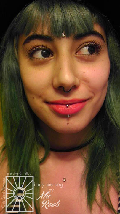 Forehead and chest surface anchors with 4mm clear rhinestones, septum piercing wearing a 16 gauge (1.2mm) Niobium continuous ring, and vertical labret wearing a 16 gauge (1.2mm) implant-grade titanium curved barbell from Industrial Strength.