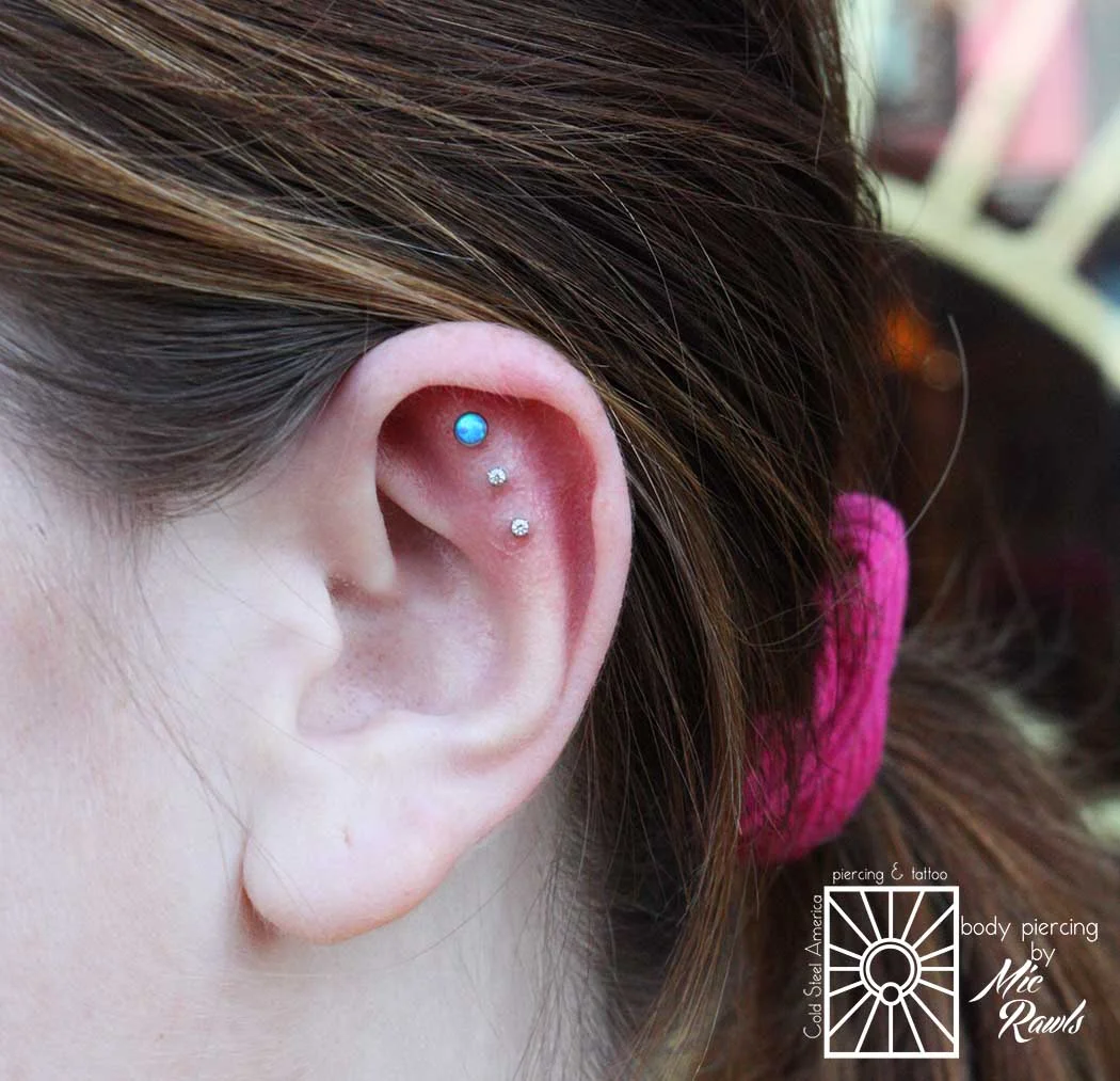 This little triple helix project Mic did on this wonderful client is about 9 months old in this photo, and looking great! 18g (1mm) titanium jewelry from NeoMetal, with a 3mm synthetic Capri Blue Opal and 2mm clear cz's.