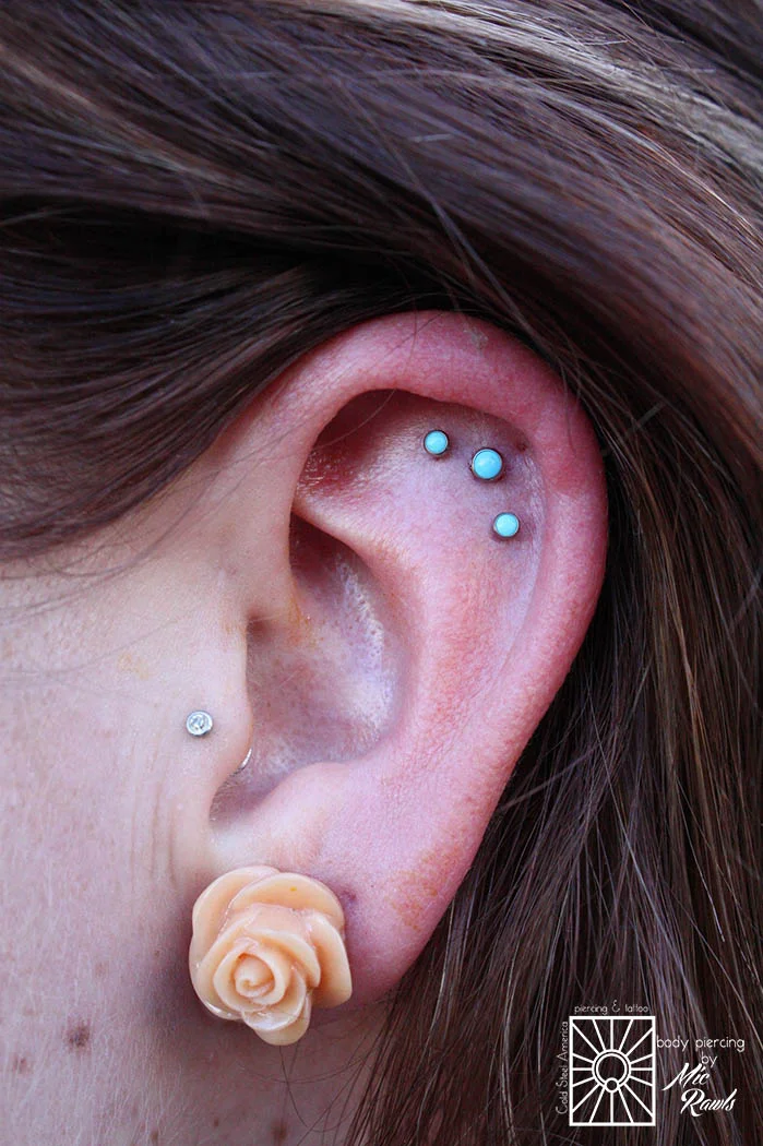 We never get tired of triples! Fresh helix piercings wearing 18g (1mm) implant-grade titanium push-pin barbells with 2.5mm and 3mm Turquoise from NeoMetal.