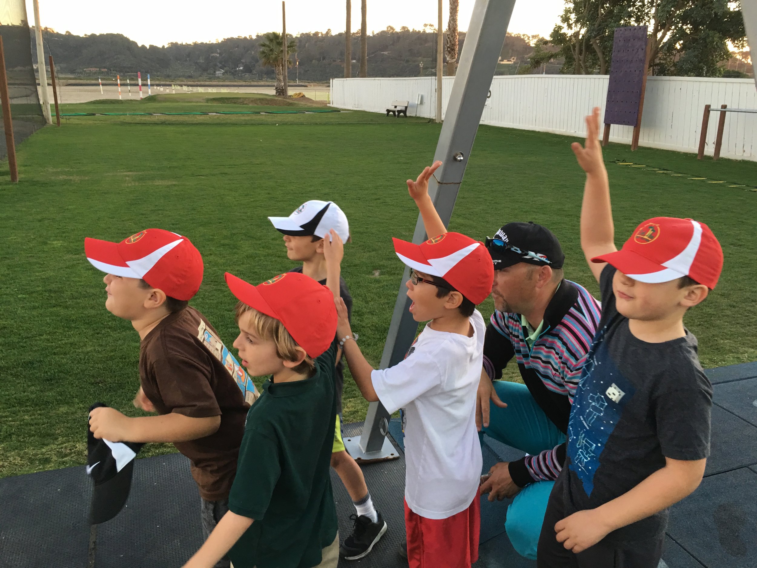 Young athletes proudly sporting the hats they earned for their golf prowess.