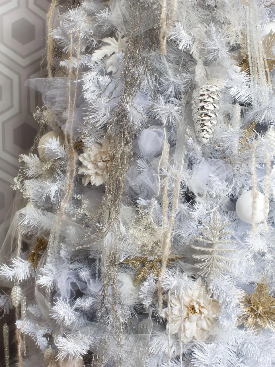 Winter white is always a great choice for the classic Fashionista. Burlap flowers and tulle add background while the classic gold ornament take center stage. C/O Hgtv. Photo by Brian Patrick Flynn