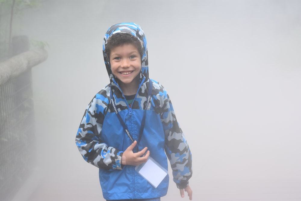 Boy running through the mist at the Fort Wayne Children's Zoo