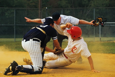 A player is tagged at a base. The referee indicates OUT! ©iStock