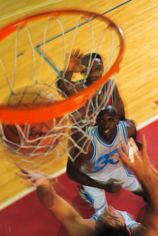 Players shoot for goal. The ball must pass through the hoop and the basket for a score. ©iStock