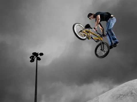 Freestyle park riders perform tricks in the air at an arena full of ramps. ©Getty Images