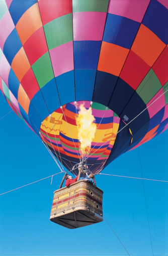 Heat makes the air inside the balloon less dense than the air outside, so the balloon floats. Getty Images