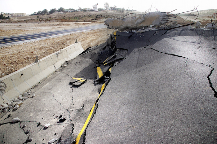 A road buckled and broken by an earthquake. ©iStock