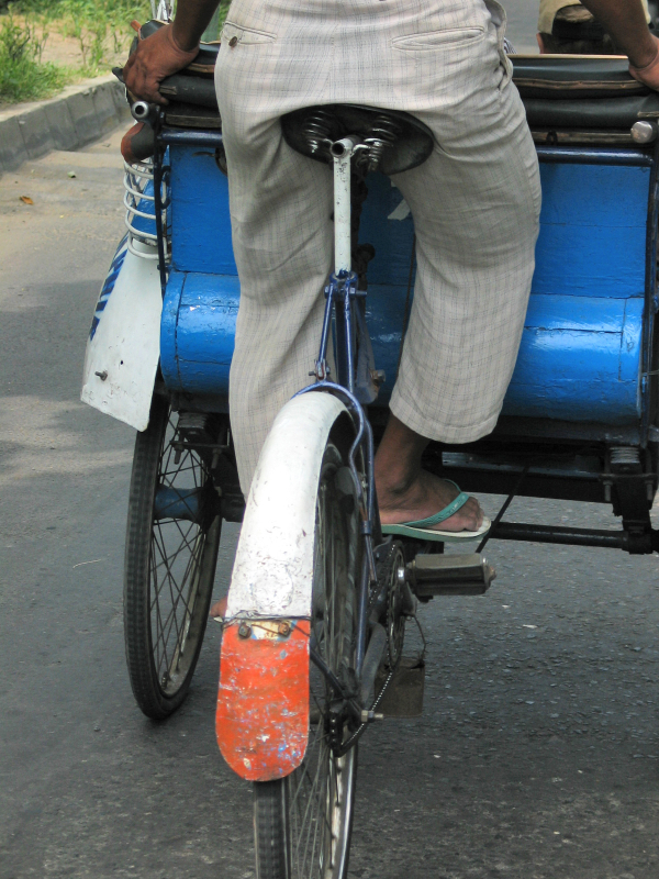 The becak driver pedals his vehicle. Just like pedalling a bicycle!
