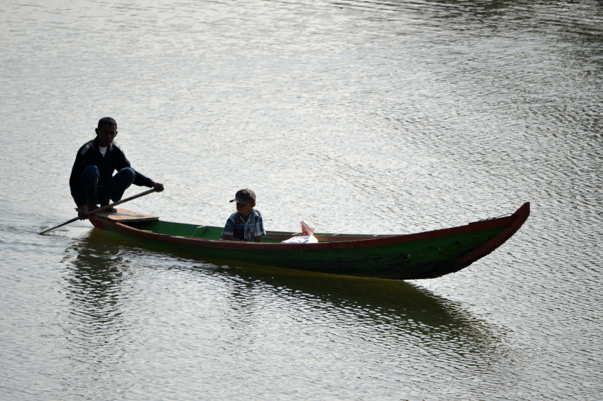 Small boats are used by farmers and families living by a river.